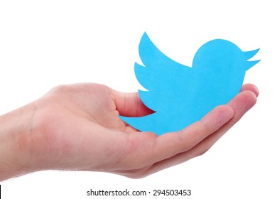 KIEV, UKRAINE - JULY 8, 2015: Hand holds twitter logotype bird printed on paper. Twitter is an online social networking service.