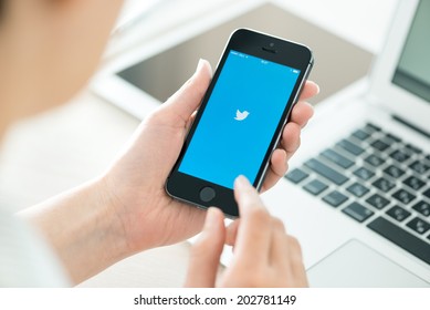 KIEV, UKRAINE - JUNE 27, 2014: Person holding a brand new Apple iPhone 5S with Twitter logo on the screen. Twitter is a social media online service for microblogging and networking communication.
