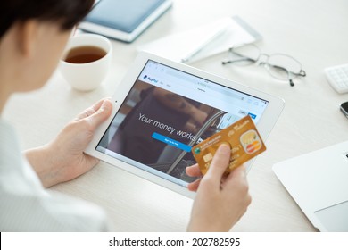 KIEV, UKRAINE - JUNE 27, 2014: Person With Credit Card Looking On A New Apple IPad Air With Paypal Website On A Screen. Paypal Is The E-commerce Business Service Allowing Payments And Money Transfers.