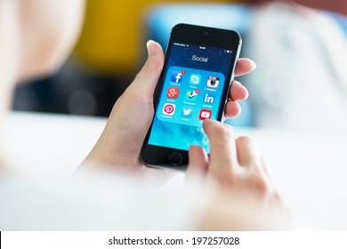 KIEV, UKRAINE - MAY 21, 2014: Woman Looking On Social Media Applications On A Brand New Black Apple IPhone 5S, Which Is Designed And Developed By Apple Inc. And Was Released On September 20, 2013.