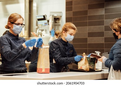 Kiev, Ukraine, October 16, 2021, Staff Of McDonald's Restaurant Gives Customers Their Takeaway Orders. Workers Are In Protective Medical Masks And Blue Latex Gloves. 