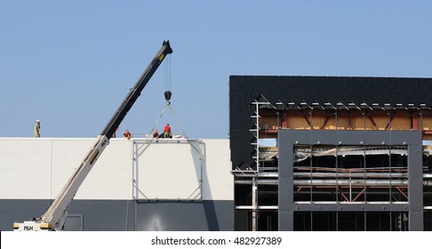 KIEV, UKRAINE - SEPTEMBER 13, 2016: Workers Install Big Billboard On The Unfinished Building Supermarket. Construction Crane. 