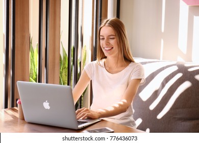 KIEV, UKRAINE - SEPTEMBER 28, 2017: Young Woman Using Apple Macbook Air In Cafe