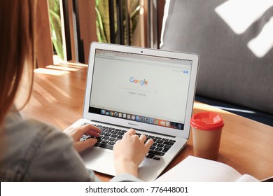 KIEV, UKRAINE - SEPTEMBER 28, 2017: Young Woman Using Apple Macbook Air With Google Search Page On Screen In Cafe