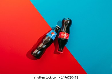 Kiev, Ukraine - September 5, 2019: two bottles of Pepsi and Coca Cola on a blue and red background