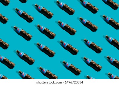 Kiev, Ukraine - September 5, 2019: glass Pepsi bottles on a blue background. Pattern