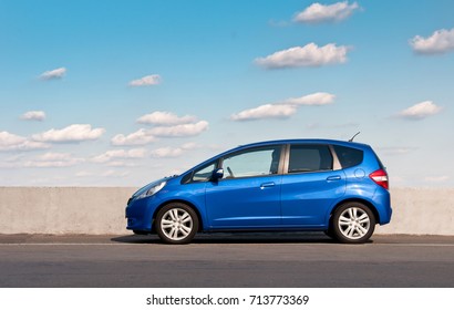 KIEV, UKRAINE-JULY 4,2017: Blue car Honda Jazz parked on the road against the background of the sunny sky. Automotive photography. Space for text. Background with car. 