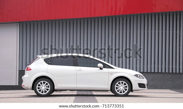 KIEV, UKRAINE-JULY 4,2017: White\
car parked on a city street. Automotive photography. Space for\
text. Urban background with car. Cityscape with car. Wall and\
car.