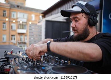 KIEV-10 JULY,2018: DJ Panchez In Headphones Plays Musical Set In Party Bar.Hip Hop Disc Jockey Mix Music Tracks With Pioneer Turntable & Sound Mixer In Nightclub Outdoor.Disco Club Entertainment Event