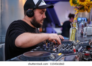 KIEV-10 JULY,2018: DJ Panchez In Headphones Plays Musical Set In Party Bar.Hip Hop Disc Jockey Mix Music Tracks With Pioneer Turntable & Sound Mixer In Nightclub Outdoor.Disco Club Entertainment Event