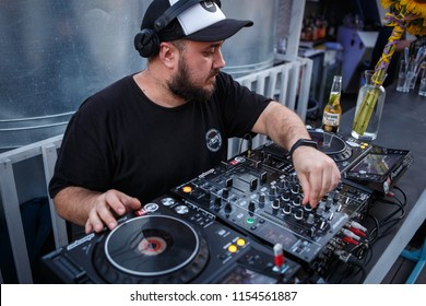 KIEV-10 JULY,2018: DJ Panchez In Headphones Plays Musical Set In Party Bar.Hip Hop Disc Jockey Mix Music Tracks With Pioneer Turntable & Sound Mixer In Nightclub Outdoor.Disco Club Entertainment Event