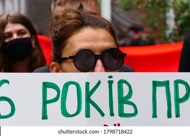 Kiev/Ukraine - 08.13.2020: close up photo of beautiful woman with sunglasses hiding her face behind protest political banner. Street action of belarissian opposition near Embassy of belarus in Kyiv