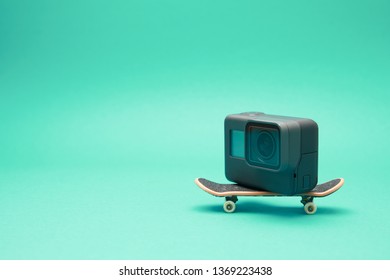 KIEV,UKRAINE,10 APRILE 2019: Close Up Of Action Go Pro Hero 5 Camera Standing On Small Toy Skateboard And Isolated On Green Background