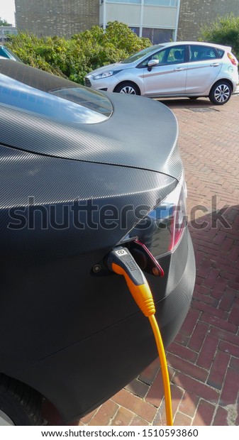 Kijkduin, the Netherlands - September 15\
2019: Tesla electric car charging batteries at plug in charge\
station in the\
Netherlands