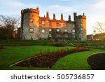 Kilkenny Castle in the evening. It is one of the most visited tourist sites in Ireland. Castle grounds with green lawn and flowers. Landmark in small town of Ireland