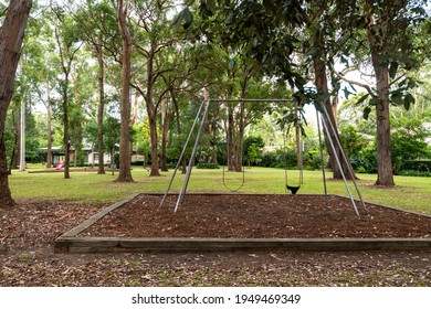 Killara, Sydney, Australia - Feb 12 2021: Ticket Of Leave Reserve - Play Equipment, Including Swings And A Slippery Dip, In A Park Filled With Trees In A Suburban Setting.