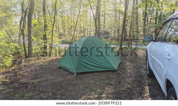 Killbear Provincial Park, Ontario, Canada - Sep
6, 2021: Set up tent next to an SUV car at a camping site. Early
misty morning, sunny
weather.
