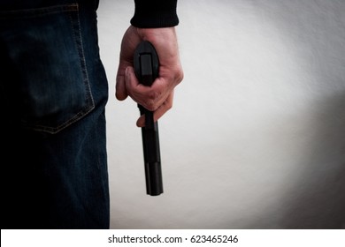 Killer Holding A Gun To His Feet, White Background In Front Of Him, Robbery, Murder, Crime