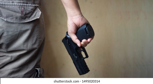 Killer Holding A  Gun Pistol Attack Violence.Crime,robbery, Murder, Crime And Violence Concept.Free Space For Text.