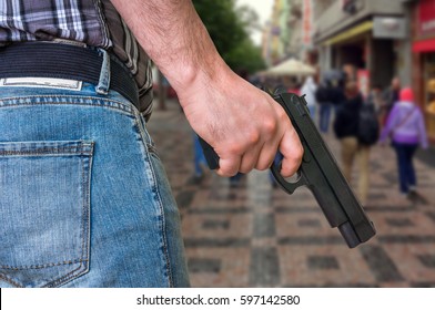Killer with pistol and crowd of people on the street - murder and crime concept