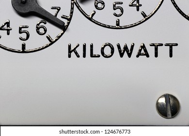 Kilowatt hour electric meter register dial digits and pointers closeup