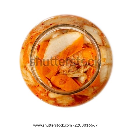 Kimchee in open glass jar isolated. Spicy kim chi, hot fermented napa cabbage, traditional jimchi, korean winter food gimchi, kimchee on white background top view