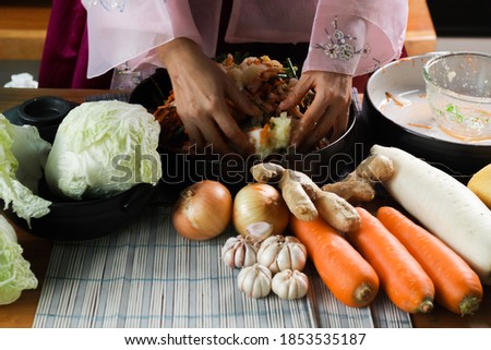 Kimchi preparation. Korean cuisine famous side dish, fermented vegetables, cabbage, radish, spicy and smelly seasonings including apple or pear, onions, garlic, ginger & spring onion