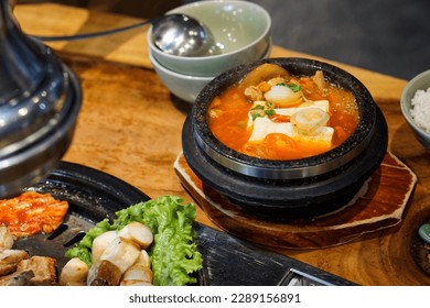 Soup Kimchi con tofu y vientre de cerdo servido en olla de arcilla, uno de los guisos más queridos de la cocina coreana, Comida más popular en Corea, Enfoque selectivo.