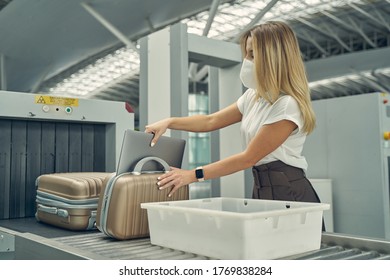 Kind blonde woman wearing protective mask while having business trip during quarantine period