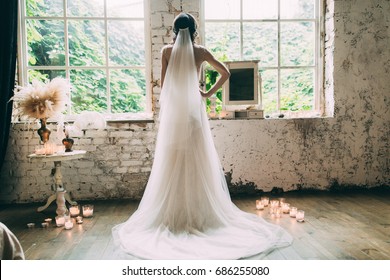 Kind of bride from the back, romantic atmosphere of the bride's morning. The bride in a white wedding dress looks out the window. - Powered by Shutterstock