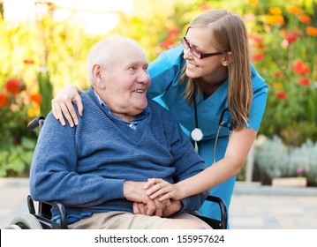Kind doctor taking care of an old man in wheelchair.
