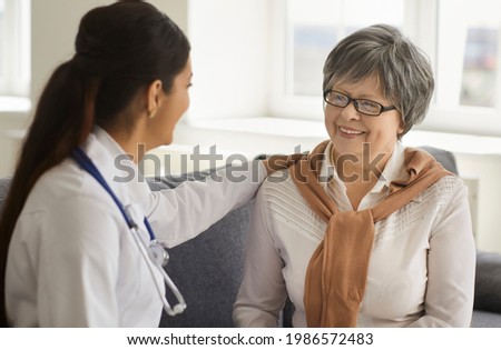 Kind female doctor consulting reassuring giving psychological support senior patient gently put her hand on shoulder. Medical service and checkup meeting at private clinic closeup portrait
