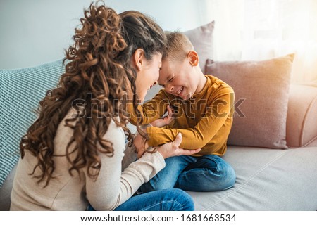 The kind of love that can't be described, only felt. Mother and her child, tickling, kidding and having fun in the couch, with spontaneous smiles. Loving my son 