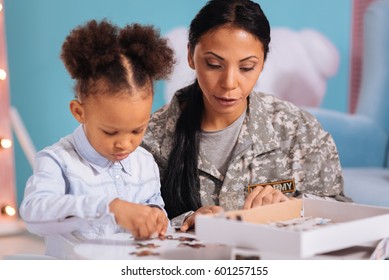 Kind Loving Mom Helping Her Child With A Puzzle