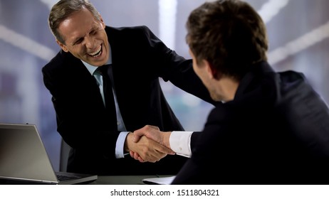 Kind Male Boss And Employee Laughing And Shaking Hands During Conversation