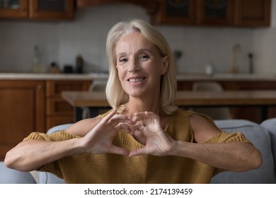 Kind Middle-aged 50s Woman Showing Heart Symbol With Joined Fingers, Smile Looks At Camera. Declaration Of Love, Advertise Medical Insurance Cover For Older Citizen, Sign Of Charity, Affection Concept