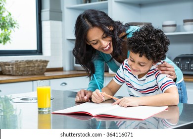 Kind mother helping her son doing homework in kitchen - Powered by Shutterstock