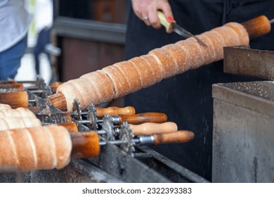 Trdelník is a kind of spit cake. It is made from rolled dough that is wrapped around a stick, then grilled and topped with sugar and walnut mix.