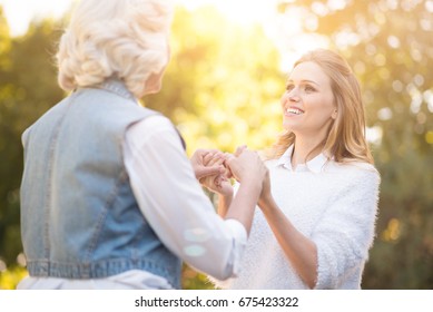 Kind Woman Holding Hands With Grandmother In The Park