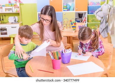 kindergarten art class - two kids and teacher - Shutterstock ID 340777499