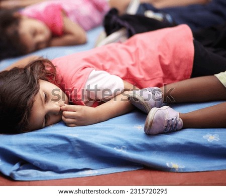 Kindergarten, children and group sleeping, relax and resting after education. Nursery, sleep and tired students take nap to rest together after learning, studying and knowledge in preschool classroom