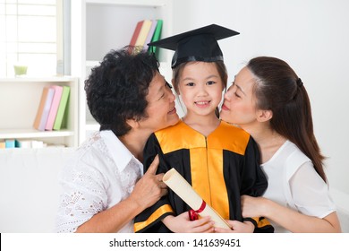 Kindergarten Graduation. Asian Family, Grandparent And Parent Kissing Grandchild On Her Kinder Graduate Day.