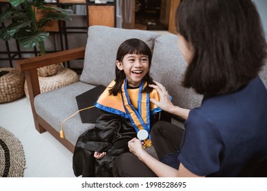 Kindergarten Graduation. Asian Family And Parent Kissing On Her Kinder Graduate Day.