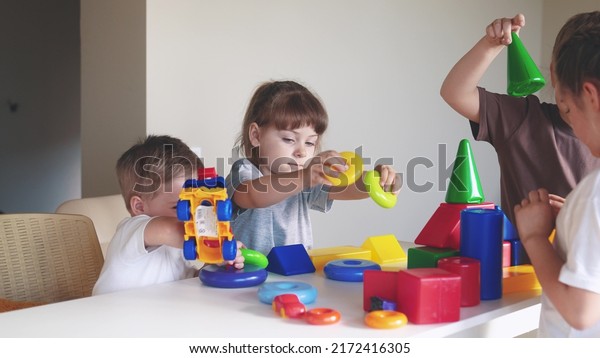 kindergarten. a group\
of children play toys cubes and cars on the table indoor in\
kindergarten. kid dream creative happy family preschool education\
concept. nursery baby toddler\
home