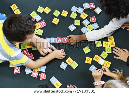 Kindergarten kids playing wooden alphabets letters vocabulary game