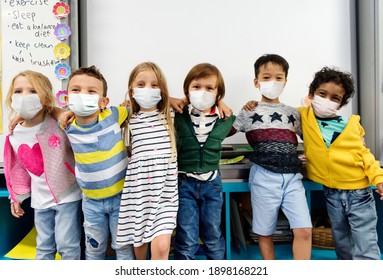 Kindergarten kids wearing masks in a classroom - Powered by Shutterstock