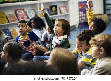Kindergarten students sitting on the floor - Shutterstock ID 704737204