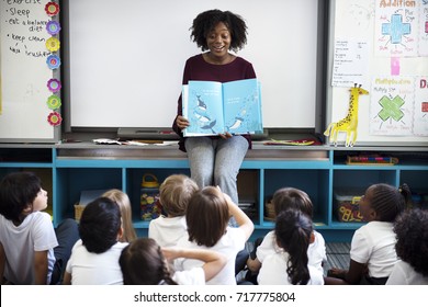 Kindergarten students sitting on the floor listening to story telling - Shutterstock ID 717775804