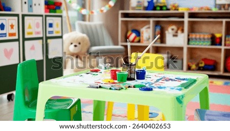 Kindergarten, table and empty classroom with paint for childhood development, art and crafts at school. Colorful, interior or equipment for drawing, creative lesson or mural activity at elementary