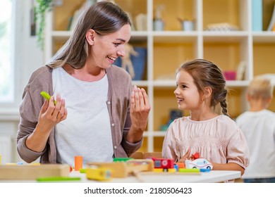 Kindergarten Teacher Playing Together With Children At Colorful Preschool Classroom. Mother Playing With Children.